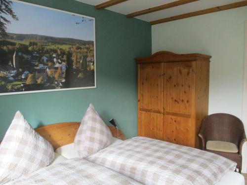 a bedroom with a bed and a picture on the wall at Gasthof Susewind in Antfeld