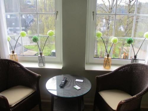a room with two chairs and a table and two windows at Gasthof Susewind in Antfeld