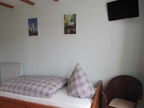 a bed with two pillows on a white wall at Gasthof Susewind in Antfeld