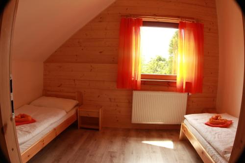 two beds in a room with a window at Vila Horček in Smokovce