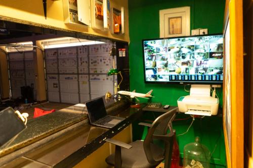 a room with a desk with a laptop and a television at Euro Hostal in Guatemala