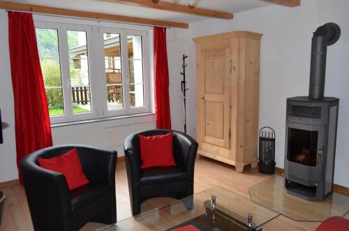 a living room with two chairs and a wood stove at Mountain-Panorama in Meiringen