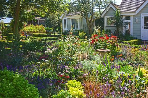 a garden with colorful flowers in front of a house at Haven Hall Hotel in Shanklin