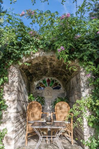 two chairs and a table in a stone wall at Hotel Rural Biniarroca - Adults Only in Sant Lluis