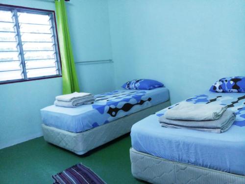 Кровать или кровати в номере Tony’s Guesthouse at Teluk Bahang