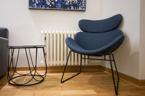 a blue chair sitting in front of a wall at Belgrade CITY CENTER Apartments in Belgrade