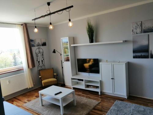 a living room with a tv and a table at Panoráma apartman in Tapolca