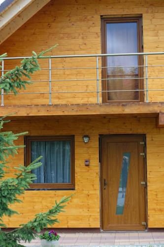 a wooden house with a balcony and a door at Vila Horček in Smokovce