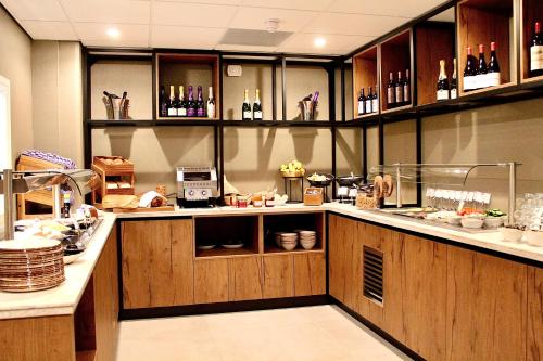 a kitchen with wooden cabinets and a counter top at Duinhotel Breezand in Vrouwenpolder