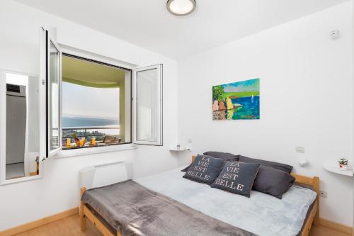 a bedroom with a bed and a large window at Smart 4 Sports Apartment in Opatija