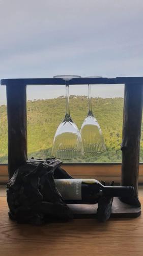 a bottle of wine and two glasses in a window at Panoramic View in ‘Isfiyā