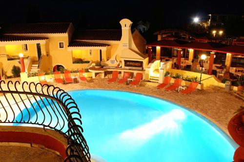 a swimming pool in front of a house at night at Mediterranean Blue in Kavos