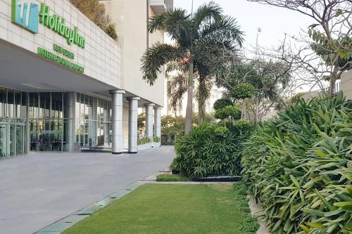 a large green building with a tree in front of it at Holiday Inn New Delhi International Airport, an IHG Hotel in New Delhi