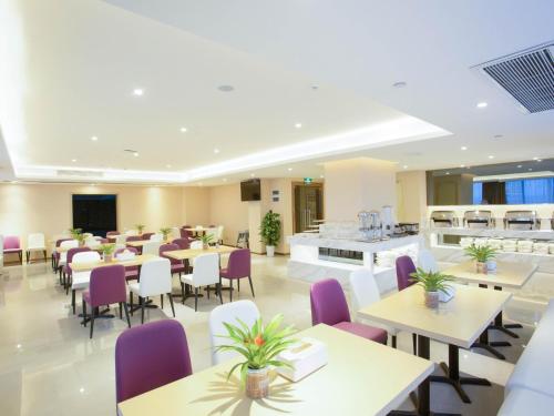 une salle à manger avec des tables et des chaises violettes dans l'établissement Lavande Hotel Nanchang West Railway Station Guobo Subway Station, à Nanchang