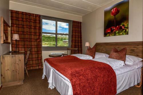 a hotel room with a bed and a window at Grotli H&oslash;yfjellshotell in Grotli
