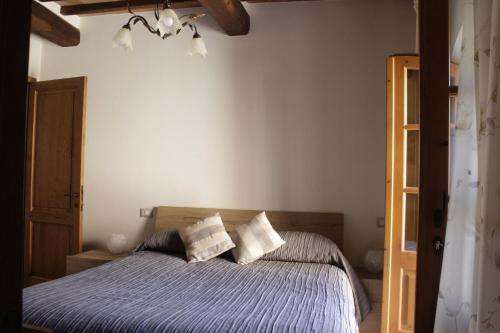 1 dormitorio con 1 cama con edredón azul en La casa di Elvira, en San Gusmè