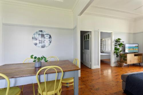 a dining room with a wooden table and chairs at Calm Waters Waterfront Cottages in Sussex inlet