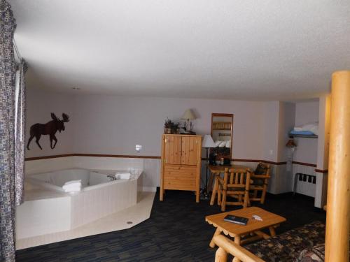 a living room with a bath tub and a table at Northwoods Best Inn - Chetek in Chetek