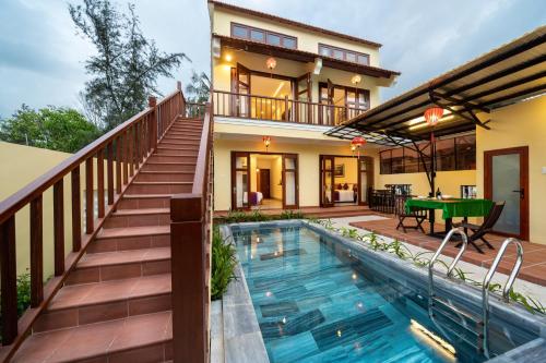 a house with a swimming pool in front of a house at Lama Beach Villa in An Bang