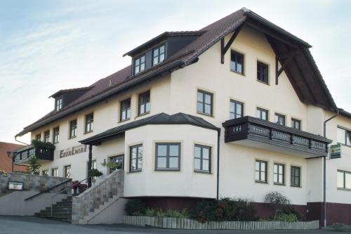 a large white house with a gambrel roof at Hotel - Restaurant Eberlwirt in Bruckberg