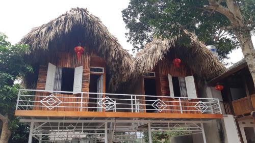 a house with a thatched roof and a balcony at Your home Mai Chau in Mai Chau