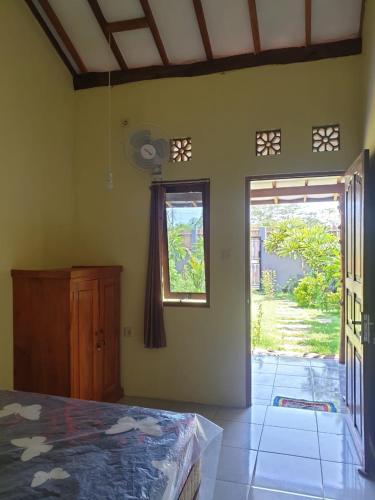 a room with a bed and a window and a door at Sunrise Banyuwangi Homestay in Banyuwangi