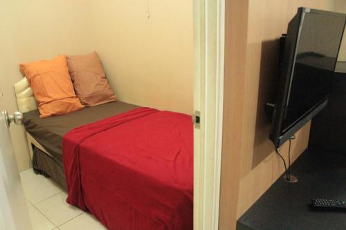 a small bedroom with a bed and a television at Kalibata city by Sang Living in Jakarta