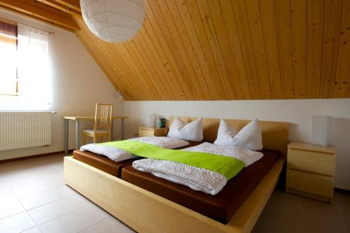 a bedroom with a large bed with a wooden ceiling at Business Homes - Das Apartment Hotel in Lauchheim