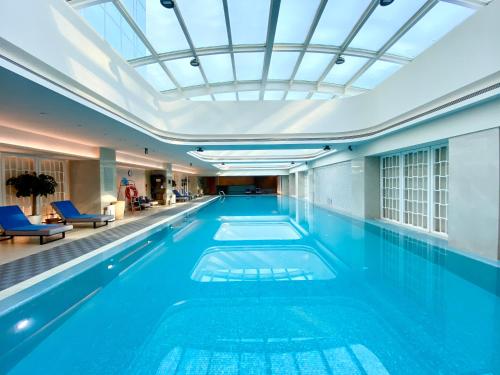 a swimming pool with a skylight in a building at The Langham, Hefei in Hefei