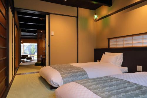 een slaapkamer met 2 bedden en een glazen schuifdeur bij Kyo no oozora SAIKA in Kyoto