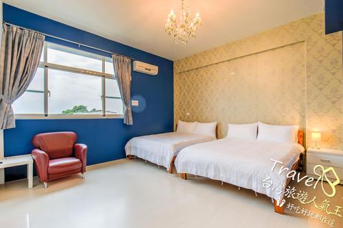 1 dormitorio con 2 camas, silla y ventana en Fashion Player House, en Taitung