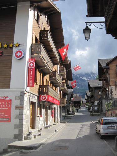 a street in a town with flags on buildings at Hotel Suisse in Champéry