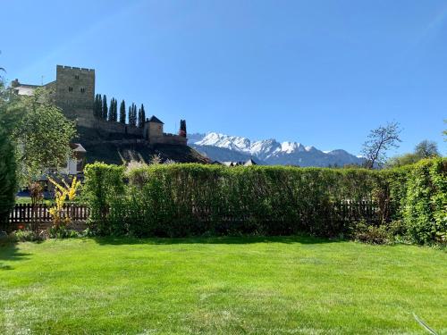 a garden with a castle in the background at Ferienhaus am Burgsee in Ladis