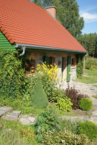 a house with an orange roof and a garden at Pustki Rekowskie - Zielone Serce Kaszub in Rekowo