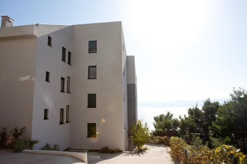 a white building with the ocean in the background at Villa Gloria in Mimice
