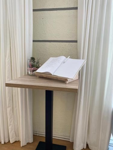 a table with a book and a pen on it at Hotel-Pension Mandy - Adults Only in Senftenberg