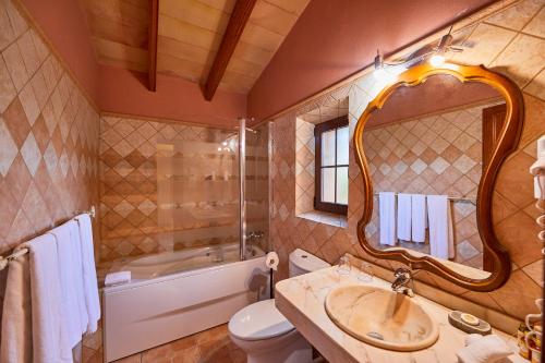 a bathroom with a sink and a toilet and a mirror at Agroturismo Es Quatre Cantons in Binissalem