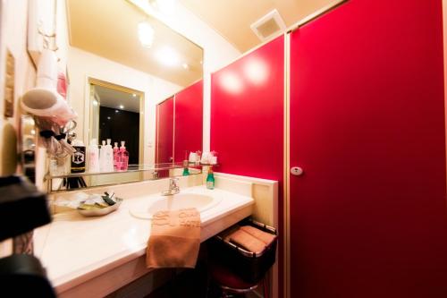 baño con lavabo y pared roja en Hotel Christmas Night at the Opera (Love Hotel), en Nishihara