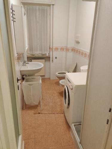 ein Badezimmer mit einem Waschbecken, einem WC und einem Spiegel in der Unterkunft Appartamento per 4 persone - Caray Park - Sale Marasino - Lago d'Iseo in Marone