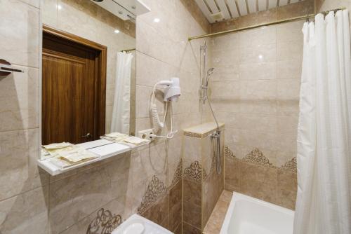 a bathroom with a shower and a sink and a tub at Inn 6 Line in Saint Petersburg