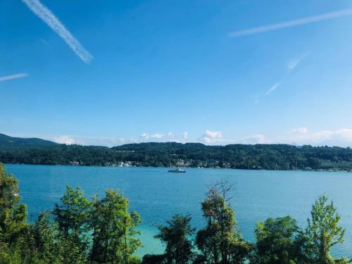 a view of a lake with a boat in the water at Villa Adrienne in Velden am Wörthersee