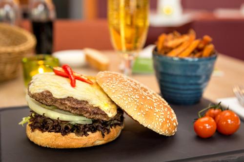 a sandwich on a plate with carrots and a drink at Holiday Inn Berlin City East Side by IHG in Berlin