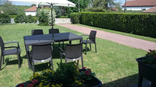a table with chairs and an umbrella in a yard at Les Gites Lussacois in Lussac-les-Châteaux