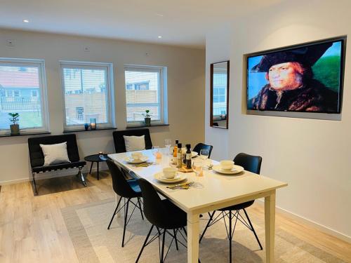 a dining room with a table with chairs and a painting on the wall at Easy Livin' Apartment Hotel in Växjö