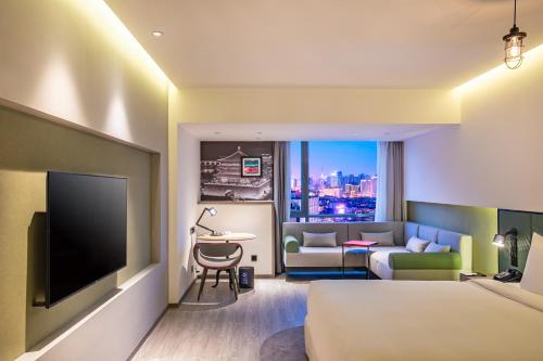 a hotel room with a bed and a tv and a couch at Jinmao Hotel Xi'an Downtown ( Bell & Drum Tower) in Xi'an