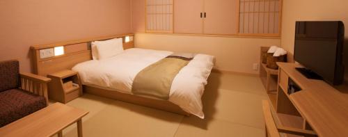 a bedroom with a bed and a flat screen tv at Onyado Nono Sakaiminato Natural Hot Spring in Sakaiminato