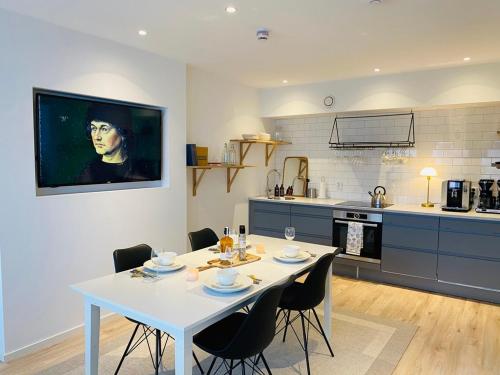 Easy Livin' Apartment Hotel في فاكخو: مطبخ مع طاولة بيضاء وكراسي في غرفة