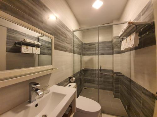 a bathroom with a toilet and a sink and a shower at Royal Hotel in Bạc Liêu