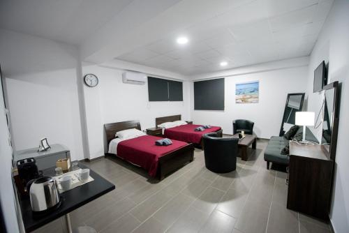 Una habitación de hotel con una cama y una sala de estar. en Central Luxury Studios, en Ayia Napa