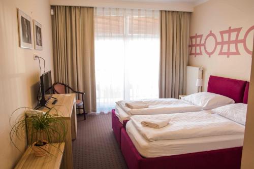 a hotel room with two beds and a window at Mini Hotel Akord in Ostrava